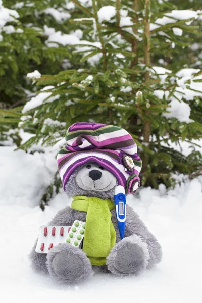 Oso de juguete con termómetro y píldora en la nieve —  Fotos de Stock