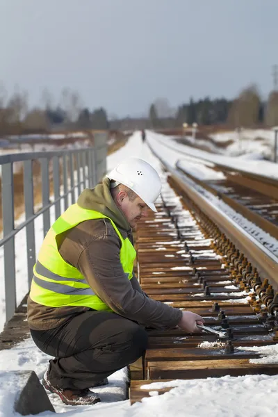 Trabajador ferroviario con llave inglesa en el puente ferroviario —  Fotos de Stock