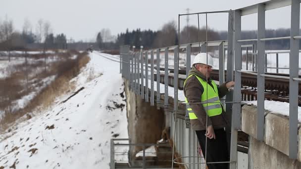 Spoorweg werknemer op de brug — Stockvideo