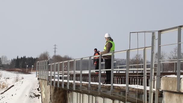 Eisenbahner machen Eisenbahnsicherheitsprüfung auf der Brücke — Stockvideo