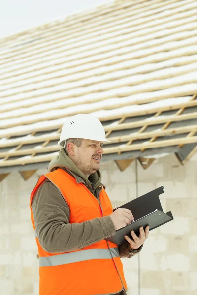 Ingeniero escribiendo cerca de nuevo edificio en invierno —  Fotos de Stock