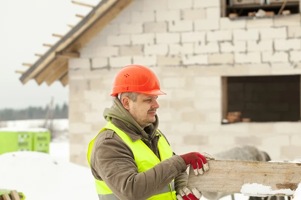 Construtor com placa nas mãos perto das obras de construção — Fotografia de Stock