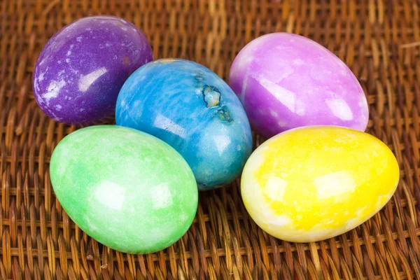 Huevos de Pascua en diferentes colores en la superficie trenzada —  Fotos de Stock
