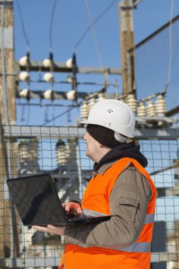Elektrikçi elektrik Trafo Merkezi yakınındaki bir bilgisayar ile