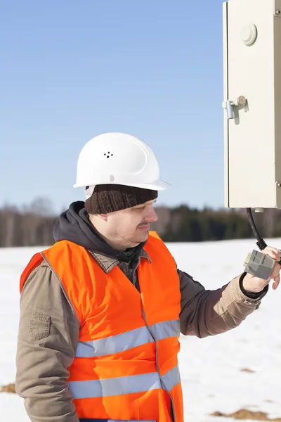 Elektrotechniker mit elektrischem Kabel in der Nähe von Schaltschränken — Stockfoto