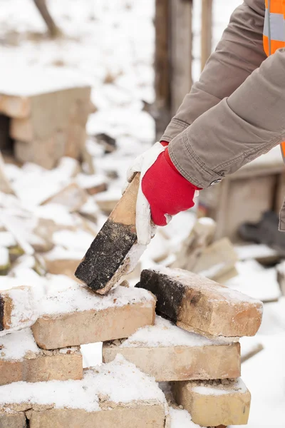 Bauarbeiter legt Handschuhe mit Ziegelstein an — Stockfoto