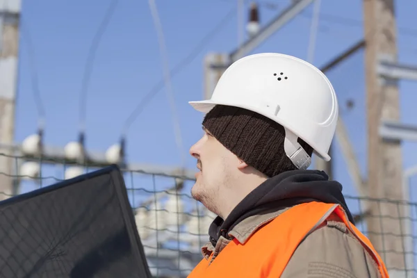 Electricista con PC cerca de la subestación eléctrica — Foto de Stock