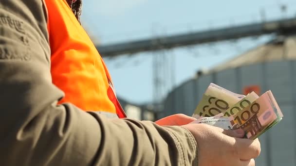 Работник руки подсчет банкнот евро рядом с заводом — стоковое видео