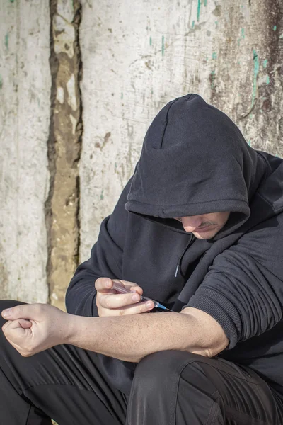 Drugsverslaafde man met spuit in handen — Stockfoto