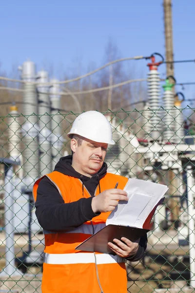 Inżynier z dokumentacją w pobliżu elektrycznych podstacji — Zdjęcie stockowe