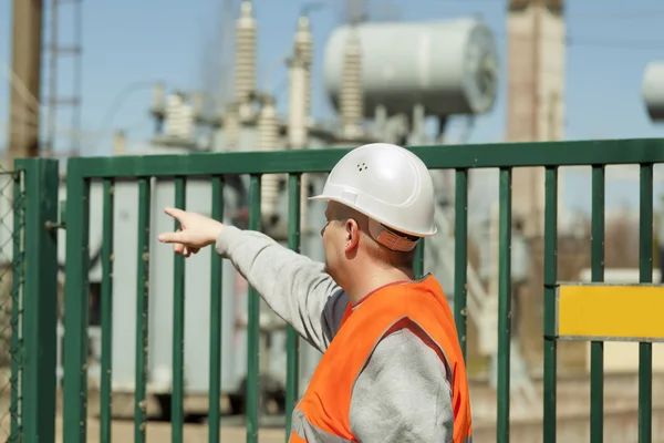 Electrician indicates to the transformer near the electrical substation — Stock Photo, Image