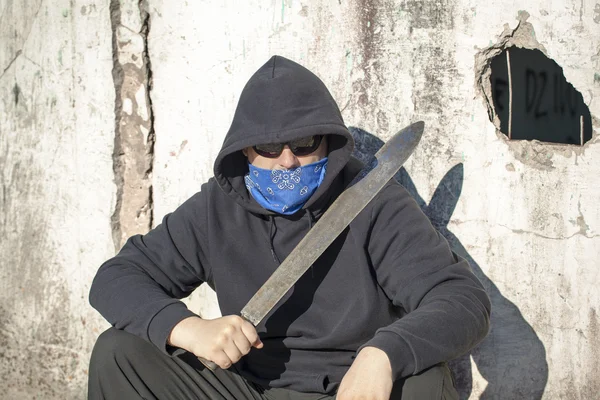 adam eski duvara yaslanmış bir pala ile