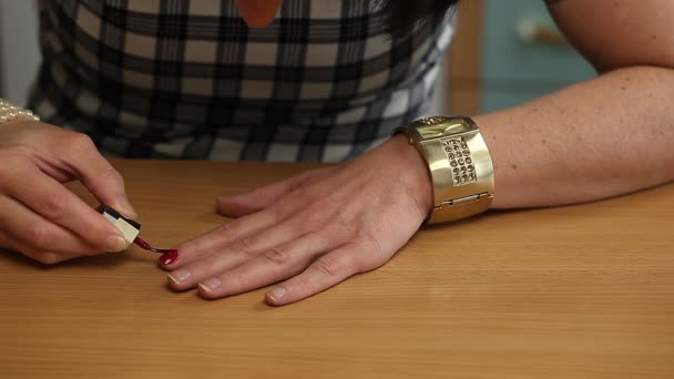Женщина наносит красный лак на ногти второй серии — стоковое видео