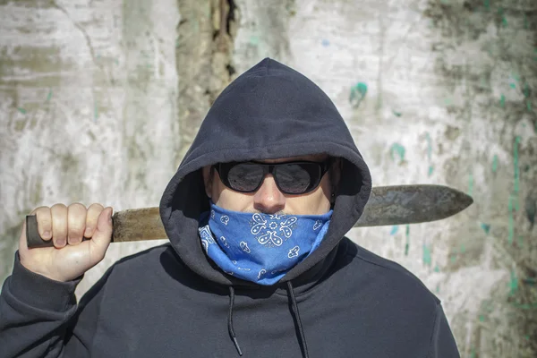 Man with a machete on a old wall background — Stock Photo, Image