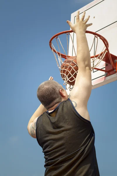 Basketbalspeler gooien de bal door de mand — Stockfoto