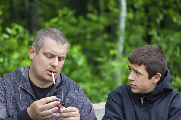 아버지는 담배를 촉발 하는 어떻게 보고 하는 소년 — 스톡 사진