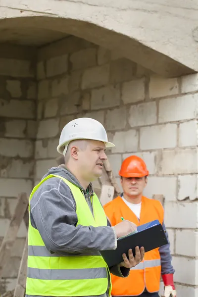 Bauinspektor mit Ordner in der Nähe des Neubaus — Stockfoto