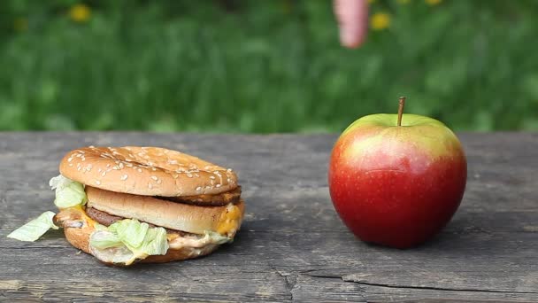 Ręka mężczyzny w pobliżu hamburgera i apple odcinek 4 — Wideo stockowe