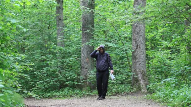 Hiker with map and binoculars on forest trails episode 1 — Stock Video