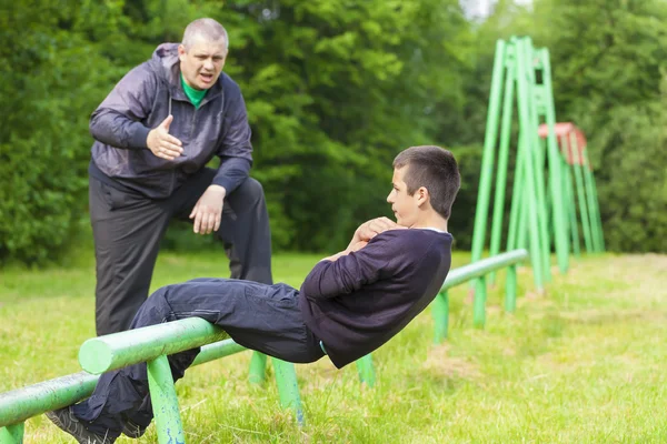 Father and son engaged in athletic exercises — Stock Photo, Image