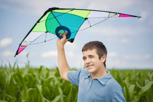 Jongen met kite op een maïsveld — Stockfoto