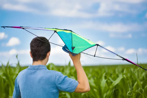 Tiener met kite op een maïsveld in de zomer — Stockfoto