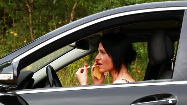 Frau mit Telefon und Lippenstift im Auto Episode 2 — Stockvideo