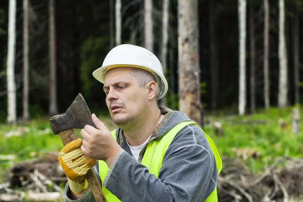 Lumberjack verificando a nitidez do machado na floresta — Fotografia de Stock