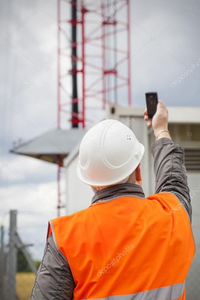 Werknemer de mobiele telefoon in de buurt van gsm-mast voordat de regen ⬇ Stockfoto, rechtenvrije foto door © ilze79 #30181387