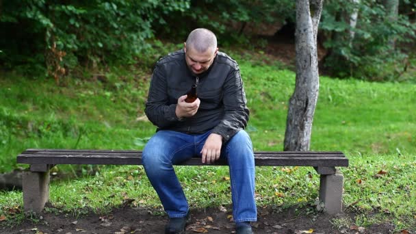 Mann mit Flasche im Park auf einer Bank Folge 3 — Stockvideo