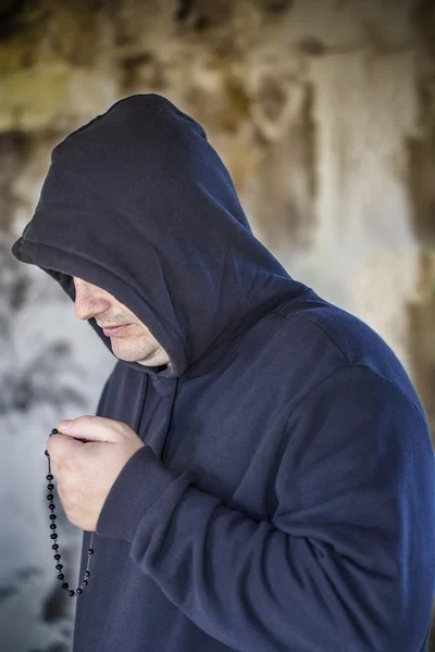 Man met een rozenkrans in oud gebouw — Stockfoto