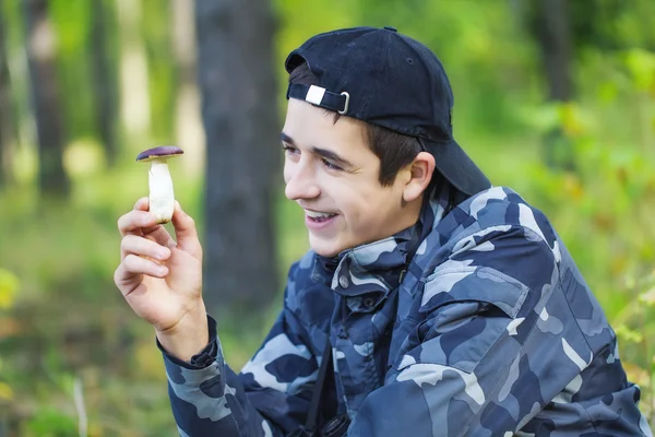 Uśmiechnięty chłopiec w lesie grzyby w ręku — Zdjęcie stockowe
