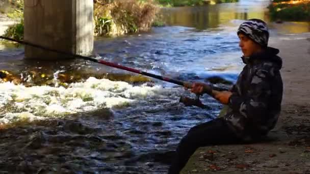 Junge angelt in der Nähe von Fluss im Herbst Episode 3 — Stockvideo