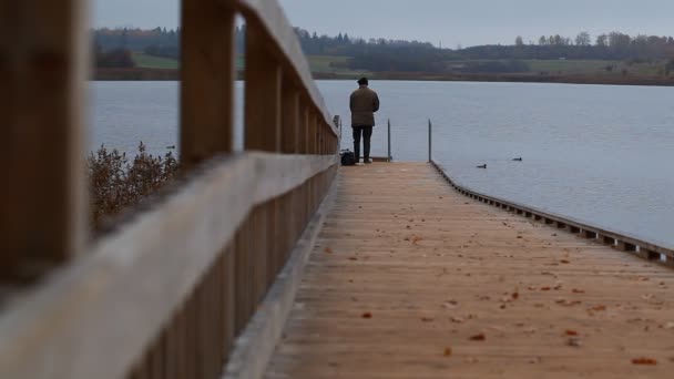 Homem pesca perto do lago — Vídeo de Stock