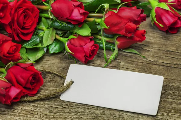 Röda rosor bukett med tomma ark på trä — Stockfoto
