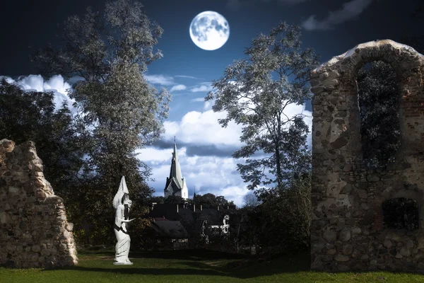 Full moon over an angel statue and castle ruins — Stock Photo, Image