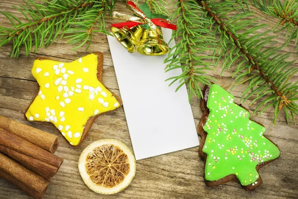 Two gingerbreads with spruce branches on old wooden table — Stock Photo, Image