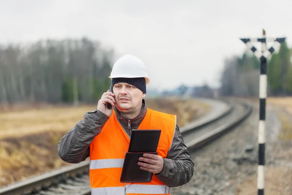 Železniční zaměstnanec s telefon tablet pc — Stock fotografie