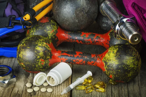 Manubri, attrezzi sportivi con pillole e medicinali — Foto Stock