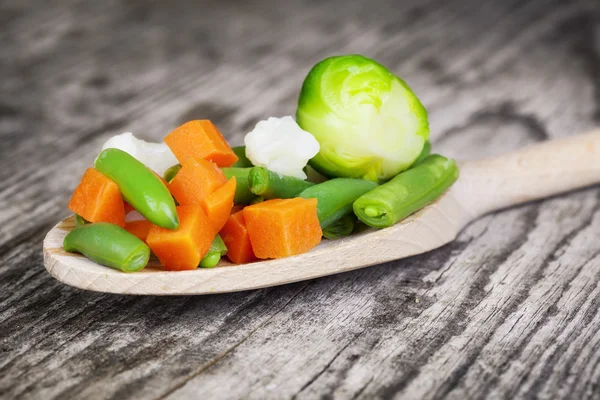 木のスプーンで古い木製のテーブルの上に野菜 — ストック写真