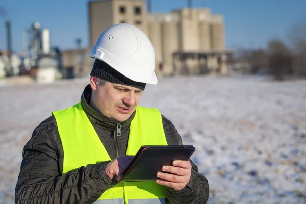 Inżynier z komputera typu tablet w pobliżu fabryki w zimie — Zdjęcie stockowe