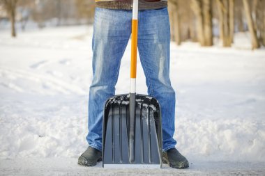 Man with a snow shovel on the trails clipart