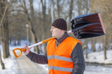 Man with a snow shovel on the sidewalk clipart