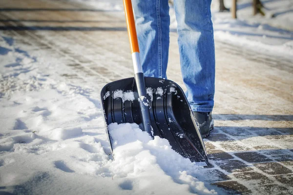 Man with snow shovel cleans sidewalks in winter — Stock Photo, Image