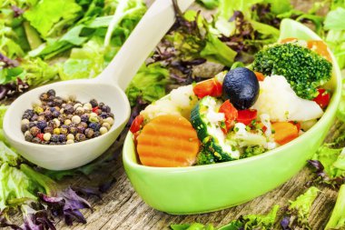 Yeşil tabak içinde beyaz peynir soslu sebze