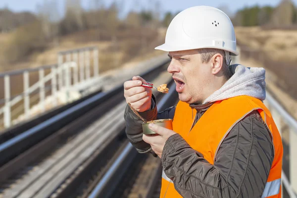 Worker with canned meat on a railway — Stock Photo, Image