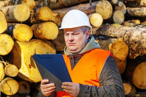 Bos werknemer met map in de buurt van Logboeken — Stockfoto