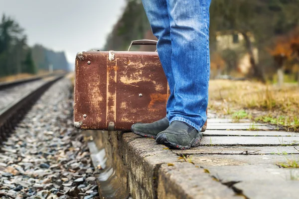 Uomo con una valigia sul marciapiede della ferrovia — Foto Stock