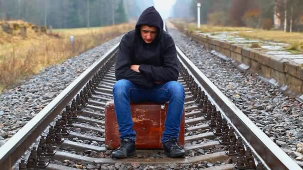 Teenage boy with a suitcase on the railway in rainy day episode 1 — Stock Video