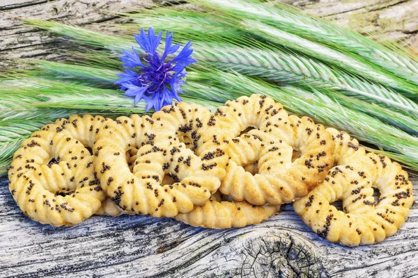 Cookies with cereal ears and cornflower on a wooden board — Stock Photo, Image